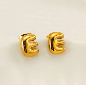 Macro shot of 18K gold plated stainless steel puffy letter E stud earrings with mirror finish