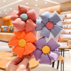 Close-up of four colorful floral fabric hair ties in pink, blue, orange, and purple