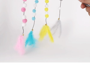Macro view of colorful plush balls and soft feathers on a pet cat wand toy attachment