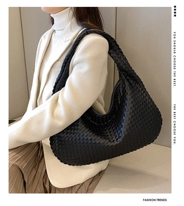 Detail of a black woven leather Hobo bag with checkerboard pattern on a shoulder strap