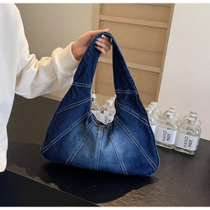 Vue détaillée du sac en jean bleu avec coutures uniques et design souple de style hobo