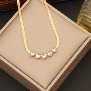Detail of gold snake chain necklace with five heart-shaped pendants and sparkling zircon