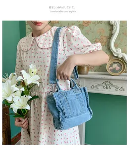 Retro light blue washed denim handbag with adjustable shoulder strap and silver buckles