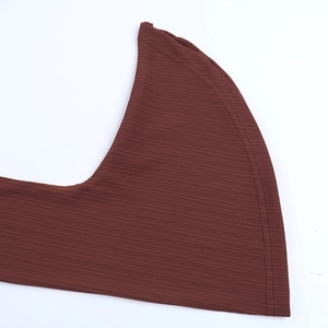 Détail du tissu en maille côtelée marron foncé montrant les finitions du poignet et de l'ourlet