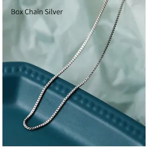 Macro shot showing detail of a polished silver box chain necklace with square links