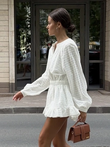 Robe courte blanche brodée avec manches lanternes et taille élastique en vue de rue