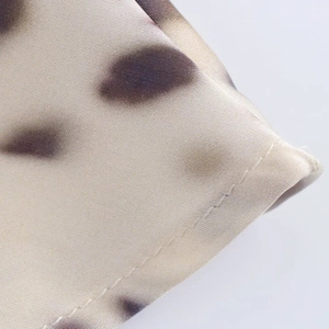 Detailed close-up showing fine stitching and beige leopard print on satin fabric