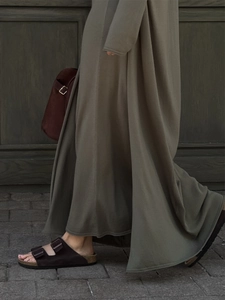 Detail of olive green knitted maxi dress paired with brown buckled slide sandals