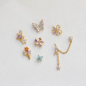 Détail de boucles d'oreilles en or 18 carats avec papillon, glace et étoile en zircon