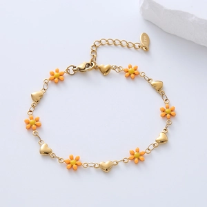 Detail showing orange and yellow flowers with heart charms on a gold-plated bracelet