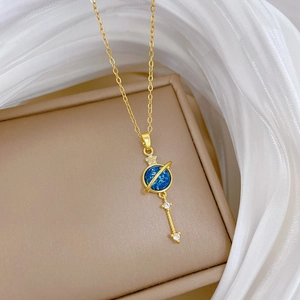 Detail of gold planetary pendant with blue center and star drop on luxury necklace