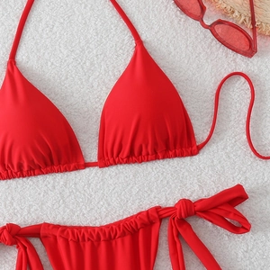 Dettaglio bikini a triangolo rosso con coppe a pieghe e slip con laccetti laterali