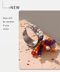Detailed view of hammered silver ring band featuring colorful beads on stone background