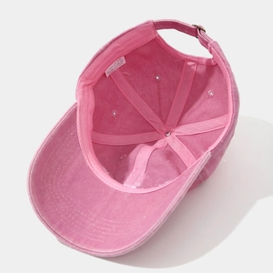 Dettaglio interno del cappello in cotone rosa con fibbia regolabile ed etichetta