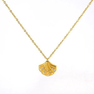 Detailed close-up of golden shell pendant necklace with white crystals inlay detail