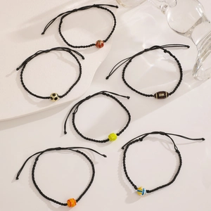 Flat lay of adjustable braided sports bracelets with basketball, soccer, and tennis beads