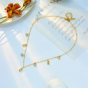 Minimalist gold necklace with geometric crystal pendants and K18 hallmark on white background