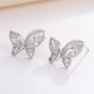 Macro view of silver butterfly stud earrings with sparkling cubic zirconia stones