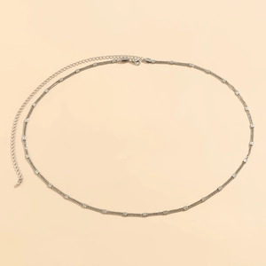 Detail of silver double-layered waist chain with textured rectangular metal blocks