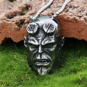 Macro shot of silver gothic devil skull pendant on natural wood and moss background
