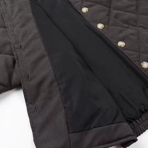Close-up of diamond-quilted grey jacket showing buttons, placket, and black lining