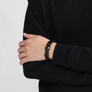 Close-up of black braided leather bracelet with magnetic metal clasp on male wrist