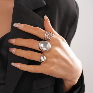 Close-up of three-piece silver geometric rings set on model wearing black blazer