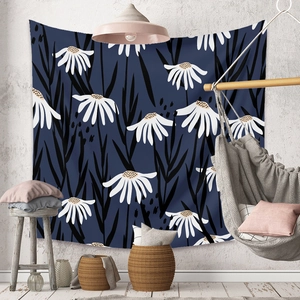 Detail of bohemian wall tapestry with white daisy pattern on navy blue fabric