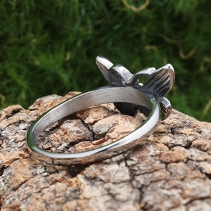 Polished silver butterfly ring made of stainless steel displayed on a natural bark base
