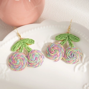 Detailed close-up of handmade bohemian cherry earrings with colorful woven spiral fruit