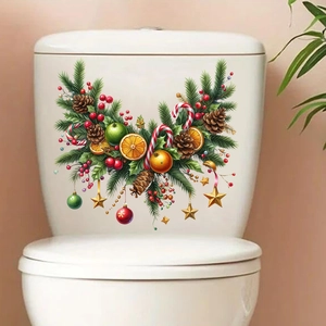 Macro detail of Christmas pine branch and berry wall stickers on a white toilet tank