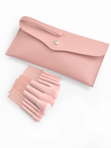 Flat lay of 8 pink makeup brushes with synthetic bristles and a matching PU leather pouch