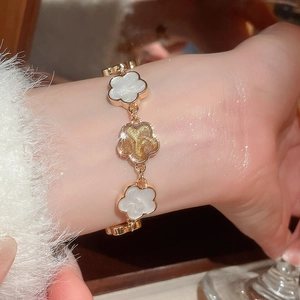 Vue détaillée d'un bracelet floral vintage français avec émail nacré blanc sur un poignet