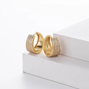 Detailed macro of gold-plated 925 silver hoop earrings with pave-set zircon stones
