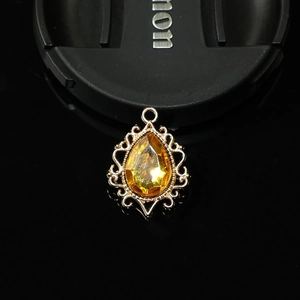 Macro d'une pierre ambre en goutte dans un cadre en filigrane doré pour création de bijoux