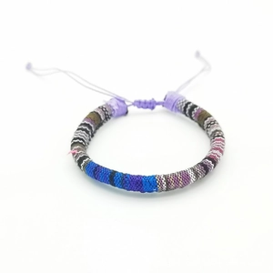 Detailed close-up of handmade bohemian woven cotton thread bracelet with adjustable knot