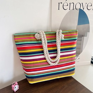 Ethnic style colorful striped canvas tote bag with thick rope handles on wooden surface