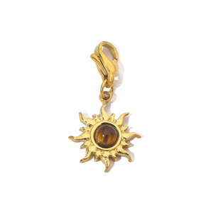 Detail of golden sun pendant with brown gemstone inlay and functional lobster clasp