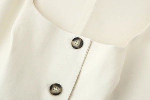Close-up of square neck waistcoat with twill fabric and dark brown buttons