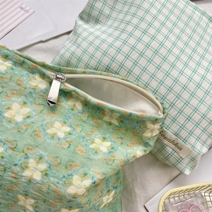 Detail view of mint green plaid makeup bag with premium fabric texture and silver zipper