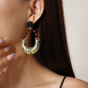Detail view of retro geometric resin earrings with gold foil leaf and bead chain