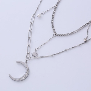 Layered silver necklace with crescent moon, star charms, and pearl detail on textured links