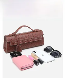 Brown ostrich texture handbag displaying storage capacity for phone and sunglasses