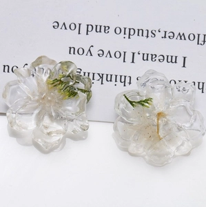 Close-up of resin flower charms with embedded dried daisies for DIY jewelry crafts