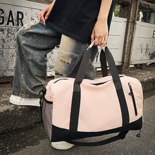 Pink and black yoga travel bag with dual handles and adjustable shoulder strap shown in use