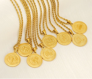 Detailed close-up of multiple 18K gold zodiac coin pendants with twisted rope chains