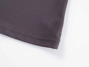 Detailed macro view of double-needle stitching on the hem of dark grey knit yoga top