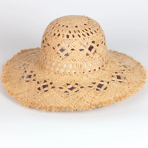 Detail of hand-woven straw hat featuring hollow diamond patterns and frayed tassel edges