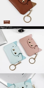 Detailed view of cute cat-shaped leather card holders with gold snap buttons and keyrings