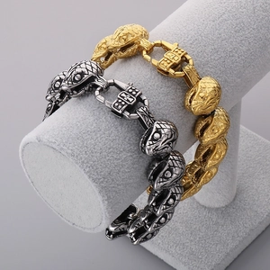 Close-up of gold and silver punk snake head chain bracelets on a display stand